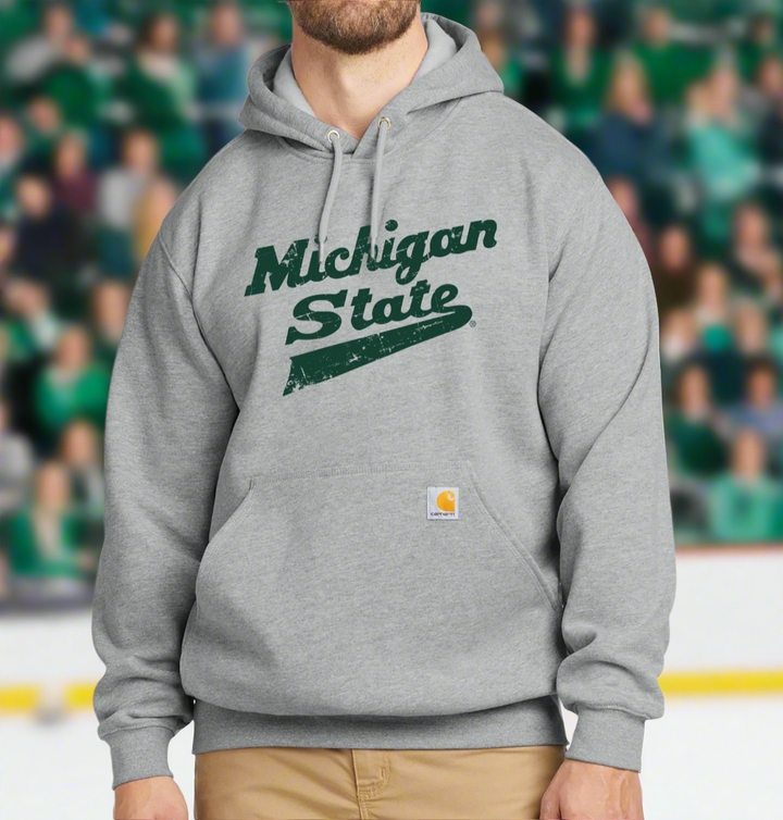 Model wearing a grey Carhartt durable sweatshirt for Michigan State and featuring a Spartan green script logo on the chest.