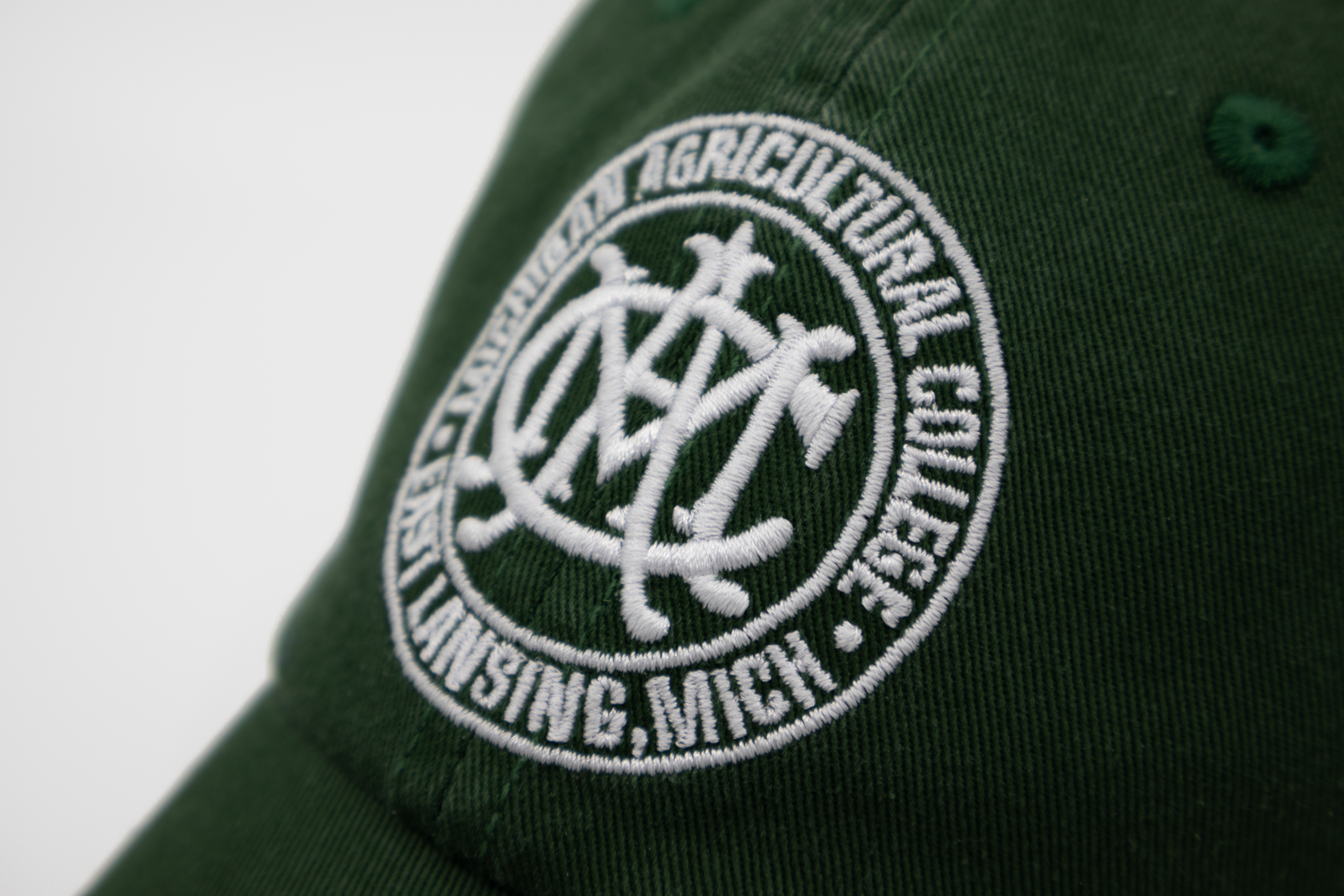 Close up of the Michigan State MAC Seal Dad Hat embroidery | Michigan Agricultural College East Lansing, MI