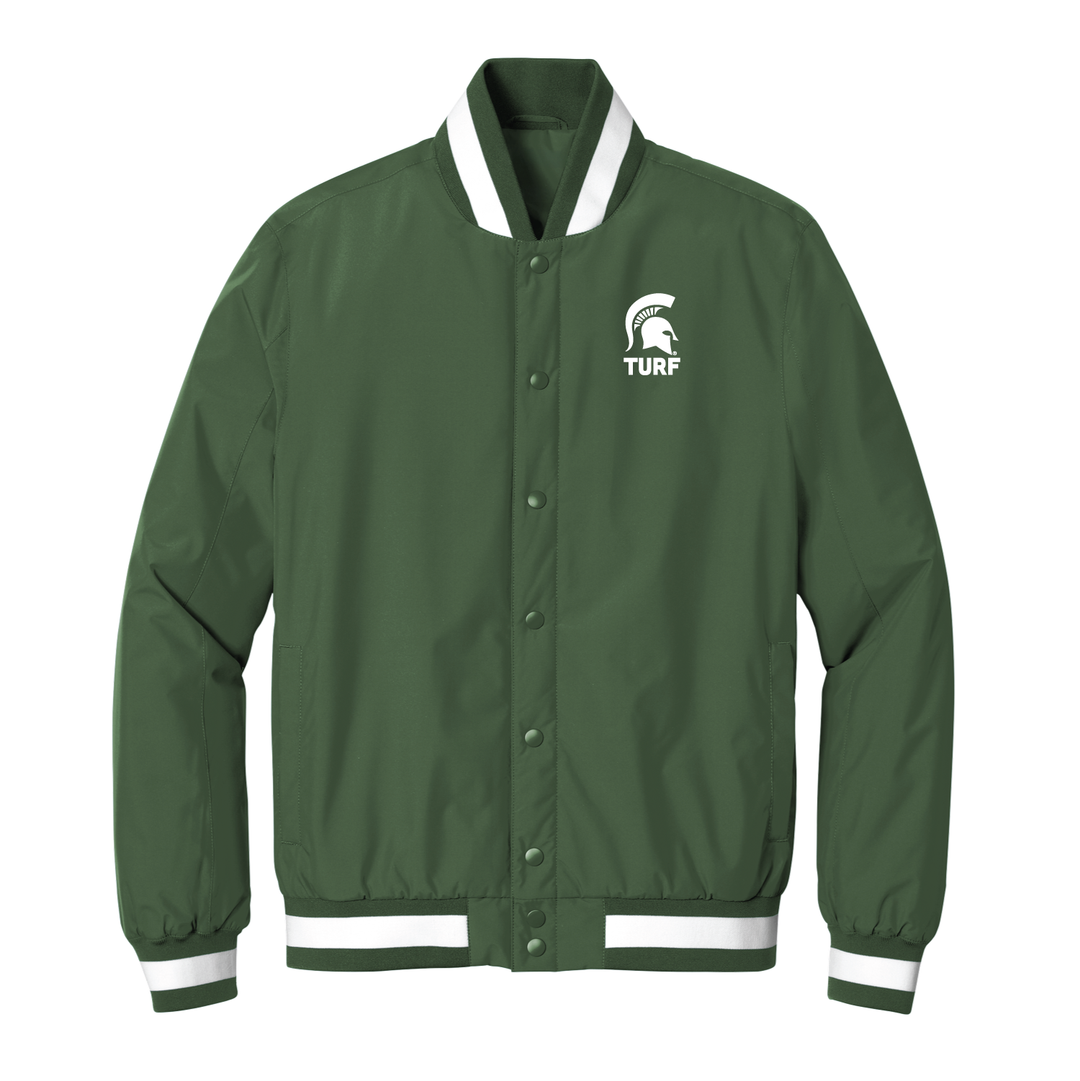 Green Michigan State Varsity jacket with with white MSU Turf logo embroidered on the left chest. 